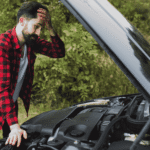 Man looking worried while checking an overheating engine and open the hood of car