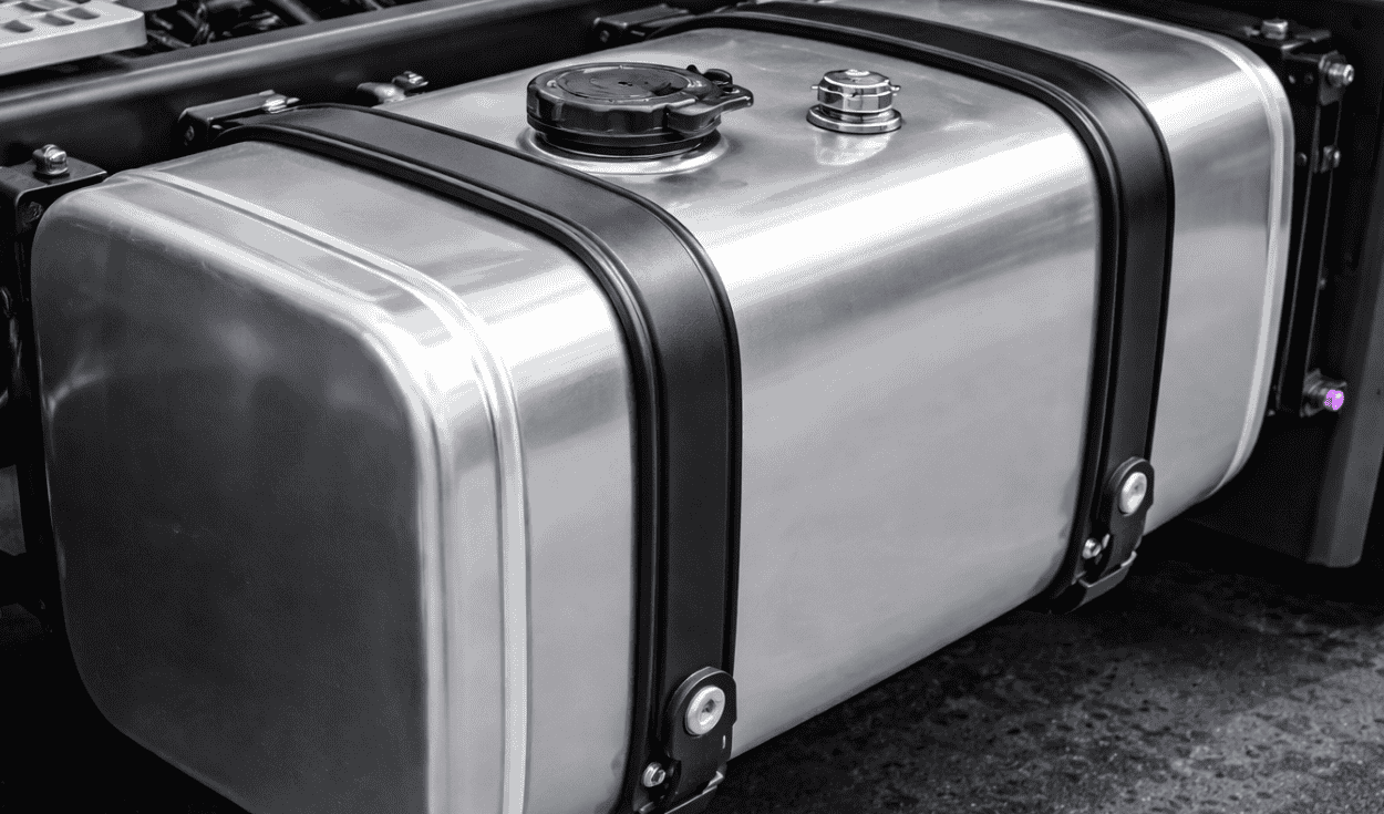 Metal vehicle fuel tank mounted on the chassis with fuel cap and securing straps.