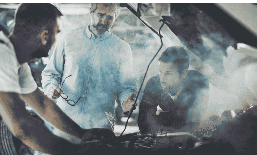 People looking at smoke coming from an engine overheating  with the hood open