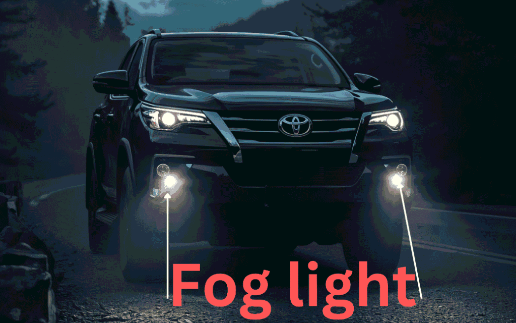 Toyota Fortuner SUV on a foggy road with headlights and fog lamps turned on during low-visibility conditions.”