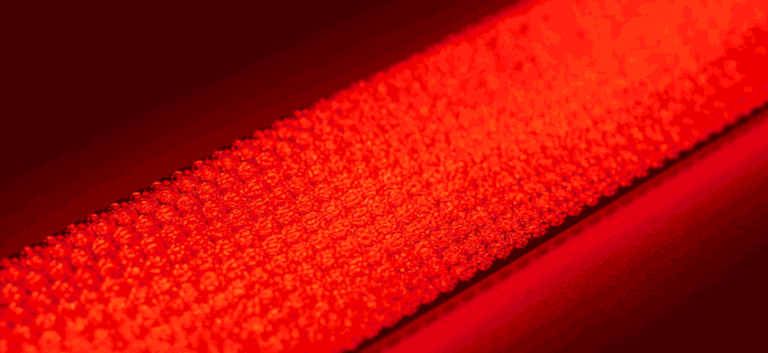 Red reflective safety tape with textured micro-prismatic surface for high visibility
