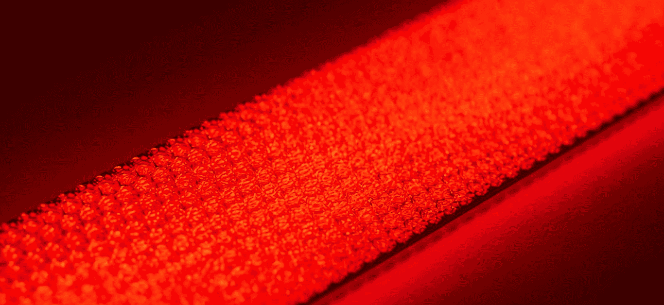 Red reflective safety tape with textured micro-prismatic surface for high visibility